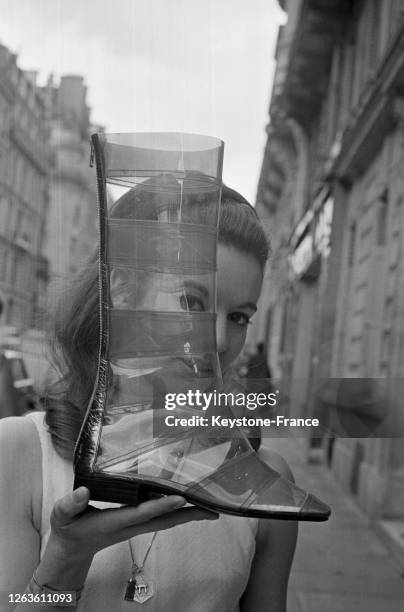 Chaussette de verre', botte fantaisie en cristal plastique transparent avec petit talon cubiste, création du célèbre bottier Roger Vivier, à Paris,...