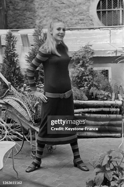 Mannequin portant une robe mi-longue de lainage avec manches longues à rayures et bas à rayures, à Paris, France le 27 juillet 1966.