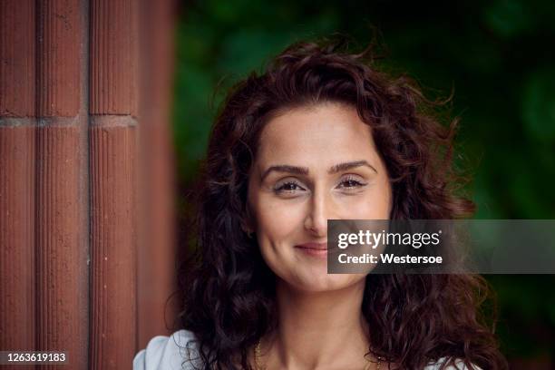 femme posant devant l’entrée de la maison - yeux bruns photos et images de collection