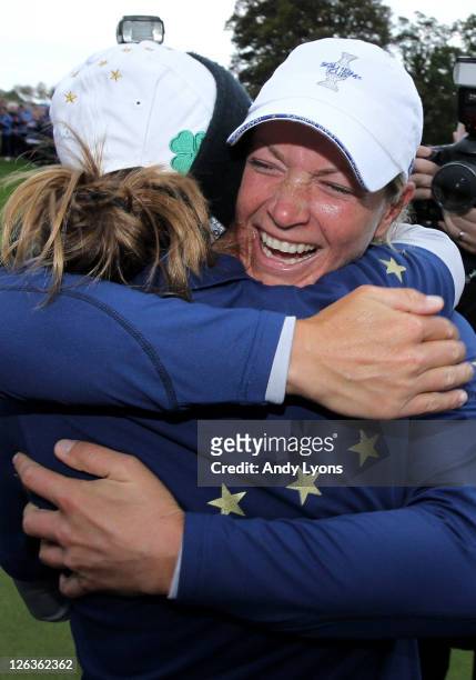 Suzann Pettersen of Europe celebrates her team's 15-13 victory on the 18th green with Azahara Munoz during the singles matches on day three of the...
