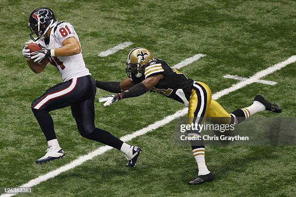 Owen Daniels of the Houston Texans slips a tackle to score a touchdown around Roman Harper of the New Orleans Saints at Louisiana Superdome on...