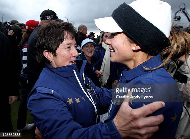 Europe Captain Alison Nicholas congratulates Azahara Munoz following her team's 15-13 victory on the 18th green during the singles matches on day...