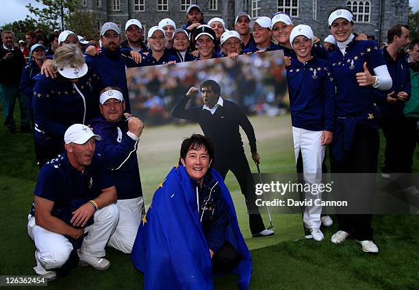 The Europe team and Captain Alison Nicholas celebrate their team's 15-13 victory on the 18th green with a giant picture of the late Seve Ballesteros...