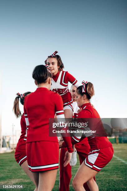 cheerleader team creating a perform - cheerleader stunt stock pictures, royalty-free photos & images