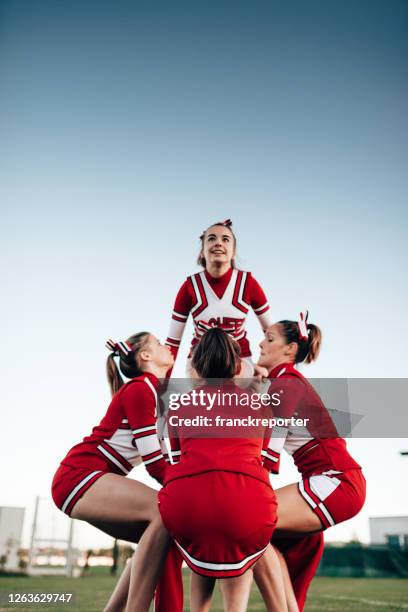 cheerleader-team, das eine leistung erstellt - human pyramid stock-fotos und bilder