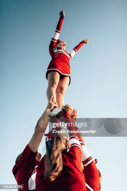 cheerleader team het creëren van een uit te voeren - mensenpiramide stockfoto's en -beelden