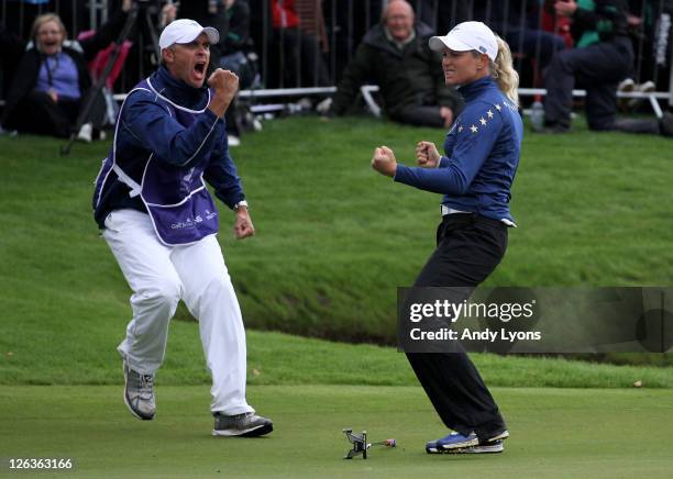 Suzann Pettersen of Europe celebrates on the 18th green with caddie Dave Brooker during the singles matches on day three of the 2011 Solheim Cup at...