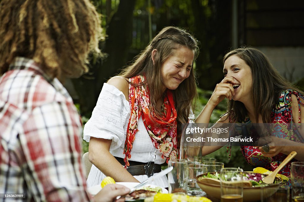 Two women laughing together at dining table