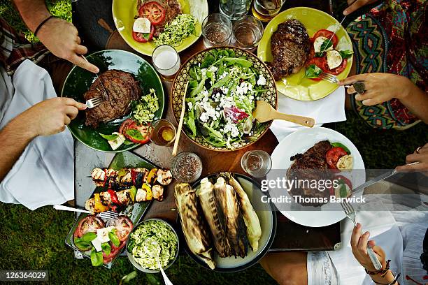 overhead view of friends dining at table outdoors - vlak erboven tafel stockfoto's en -beelden