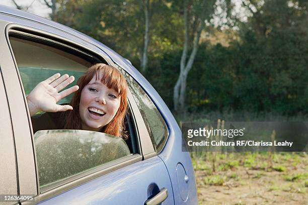 teenage girl waving from backseat of car - waving goodbye stock pictures, royalty-free photos & images