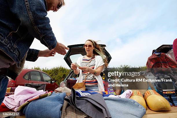 woman selling clothes from car trunk - flea market stock pictures, royalty-free photos & images