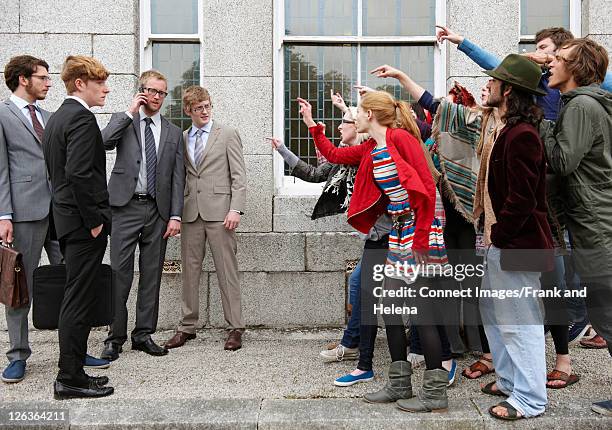 protesters jeering businessmen - business confrontation stock pictures, royalty-free photos & images