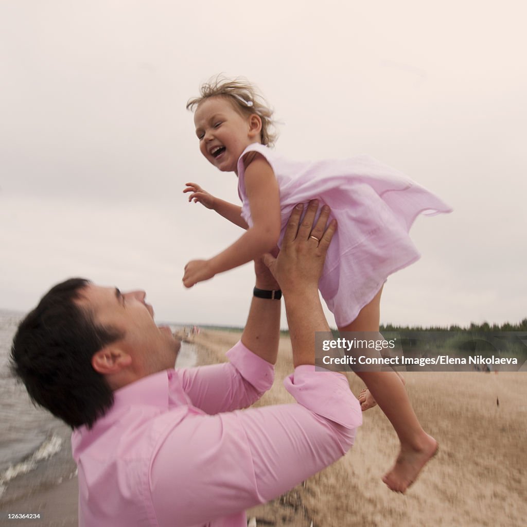 Man playing with daughter on beach