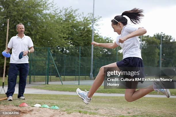 student doing long jump outdoors - mens long jump - fotografias e filmes do acervo