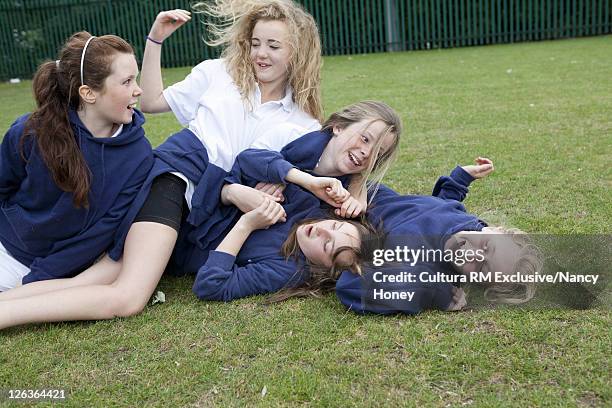 students playing together outdoors - girl wrestling stock pictures, royalty-free photos & images