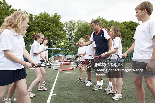 students practicing with tennis racket - tennis coaching ストックフォトと画像