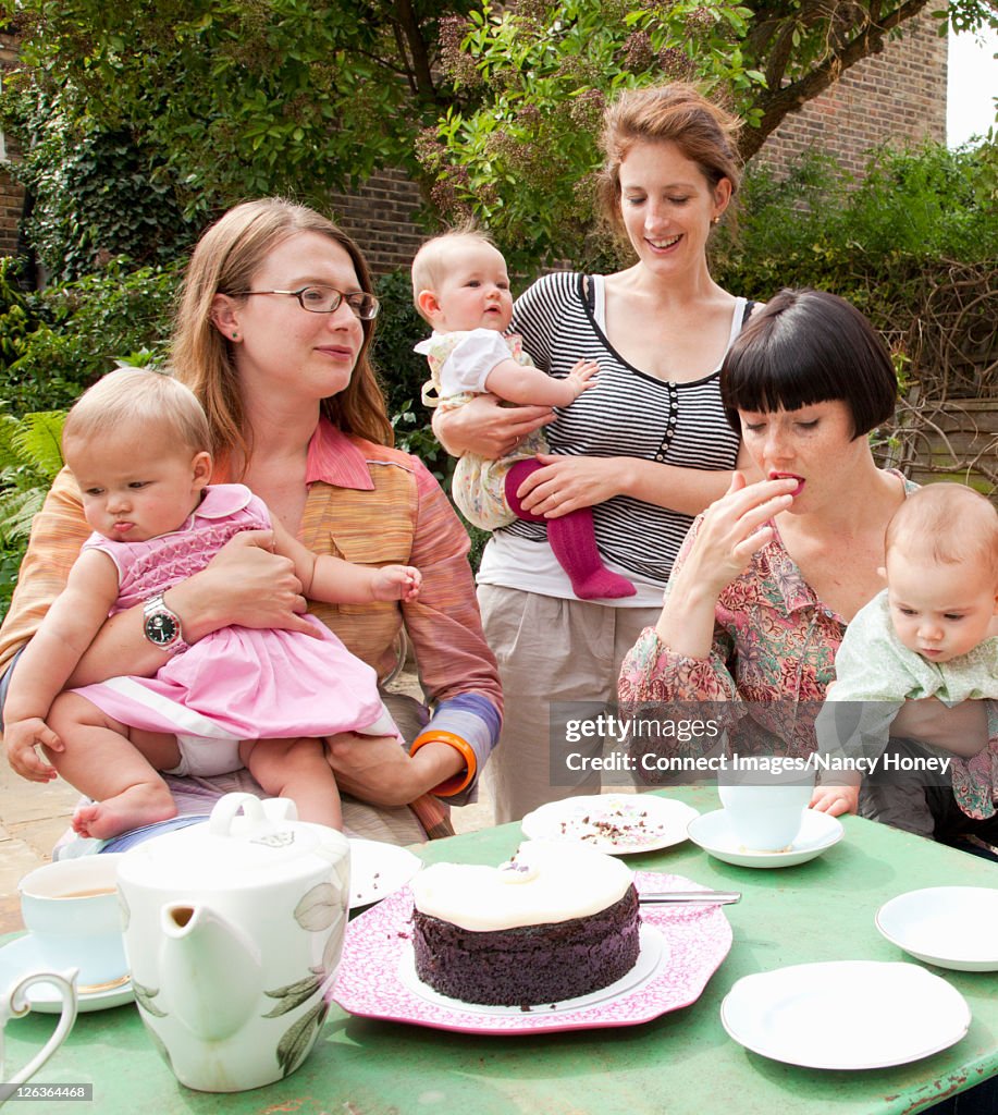 Mothers and babies having tea outdoors