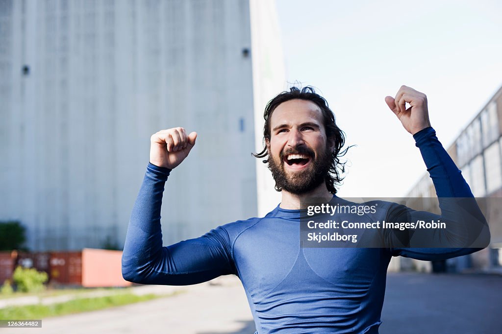 Runner cheering in industrial area