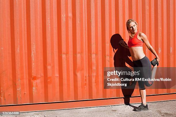 woman stretching in industrial area - refshaleøen stock pictures, royalty-free photos & images