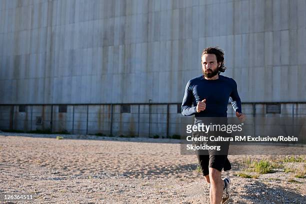 man running in industrial area - refshaleøen stock pictures, royalty-free photos & images