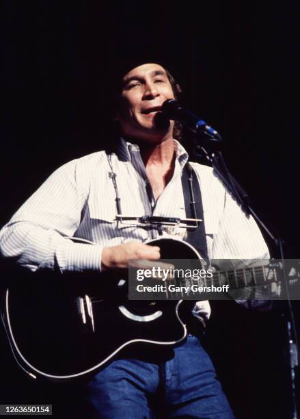 American Country musician Clint Black plays acoustic guitar as he performs onstage at the Beacon Theatre, New York, New York, June 22, 1990.