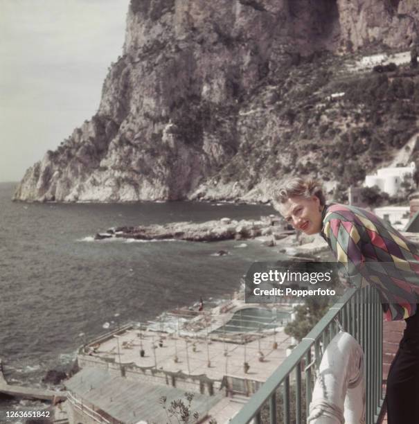 English actress and singer Gracie Fields posed on a balcony above the swimming pool at La Canzone del Mare on the Isle of Capri, Italy in October...