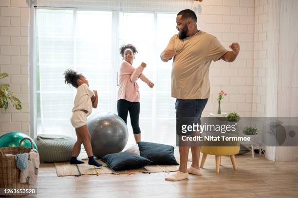 african father and his two daughter morning exercise at home. - family exercising stock-fotos und bilder
