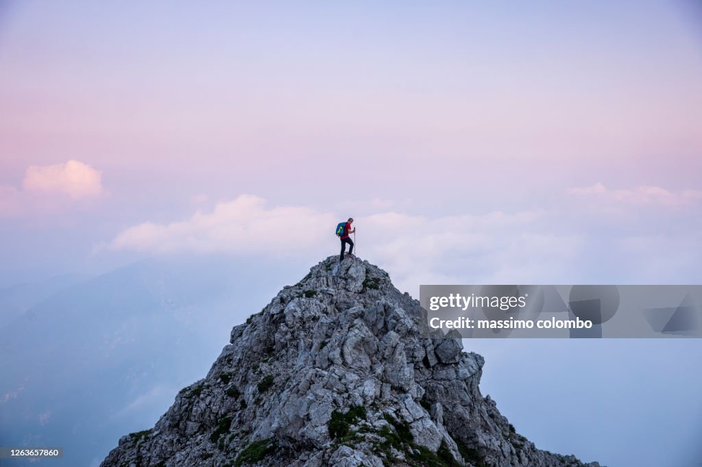 Hiker man on the top of mountain during twilight
