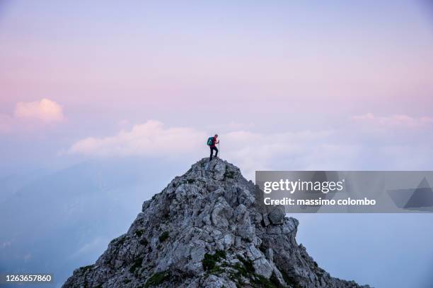 hiker man on the top of mountain during twilight - randonnée de haute montagne photos et images de collection