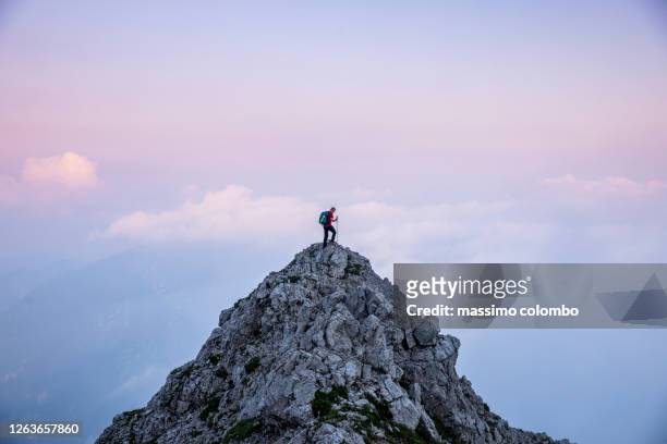 hiker man on the top of mountain during twilight - berg stockfoto's en -beelden