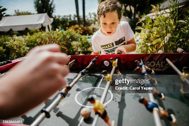 two kids plays football table in back yard in summer.pov - family back yard stockfoto's en -beelden