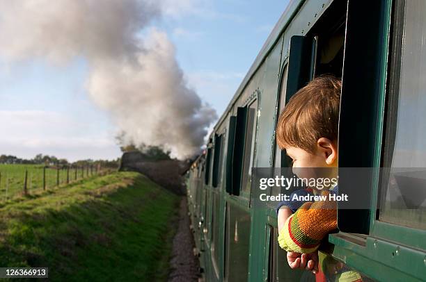 a small boy enjoying the view from a steam engine train on the bluebell railway in sussex. the volunteer run bluebell line was the uk's first preserved standard gauge passenger railway, re-opening part of the lewes to east grinstead line of the old london - station place stock pictures, royalty-free photos & images