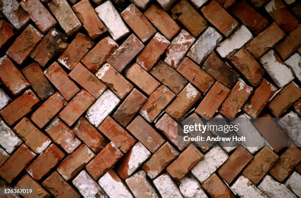 old red bricks stacked in a herringbone fashion. - bricka stock pictures, royalty-free photos & images