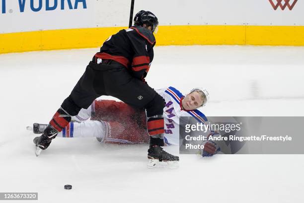 Joel Edmundson of the Carolina Hurricanes knocks Kaapo Kakko of the New York Rangers to the ground during the second period of Game Two of the...