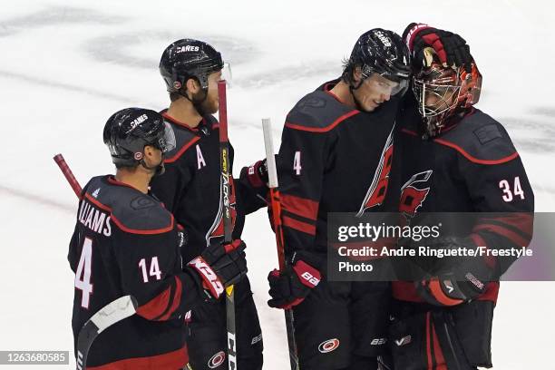 Petr Mrazek of the Carolina Hurricanes, Haydn Fleury and Justin Williams celebrate after defeating the New York Rangers 4-1 in Game Two of the...