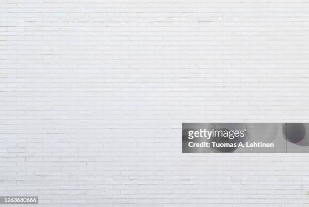 white new brick wall viewed from the front. - muro foto e immagini stock