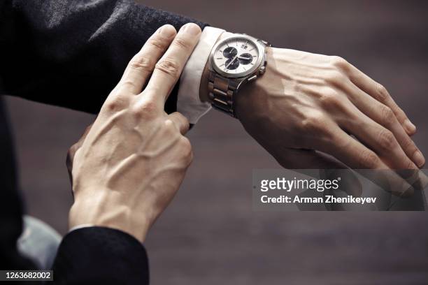 hands of businessman in formal wear with luxurious wristwatch - orologio di lusso foto e immagini stock