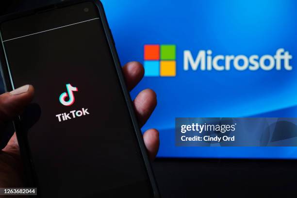 In this photo illustration, a mobile phone featuring the TikTok app is displayed next to the Microsoft logo on August 03, 2020 in New York City....