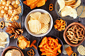 Mixed salty snack flat lay table scene on a wood background