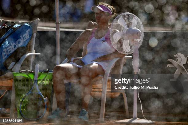 Irina-Camelia Begu of Romania takes a break as water is sprayed on the pitch during her match against Laura Siegemund of Germany during the 31st...