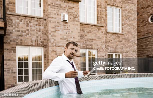 joven oligarca en su piscina - stockbrokers fotografías e imágenes de stock