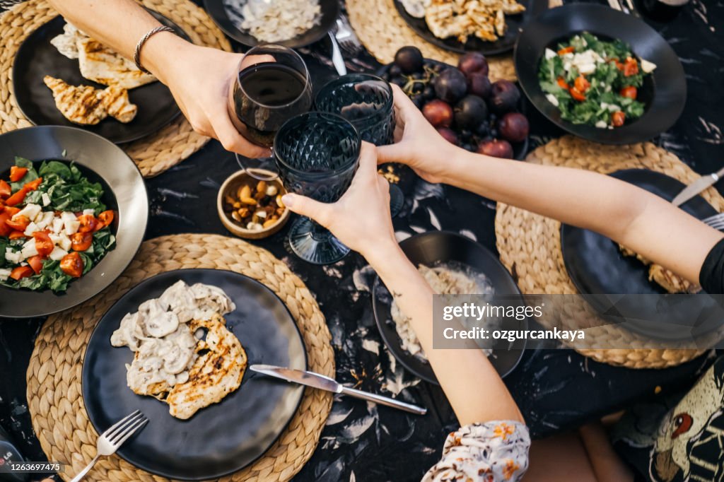 Family dinner for a celebration with red wine and cheers.