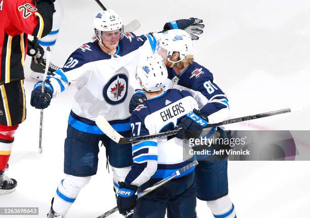 Nikolaj Ehlers of the Winnipeg Jets is congratulated by teammates Cody Eakin and Kyle Connor after Ehlers scored in the third period against the...