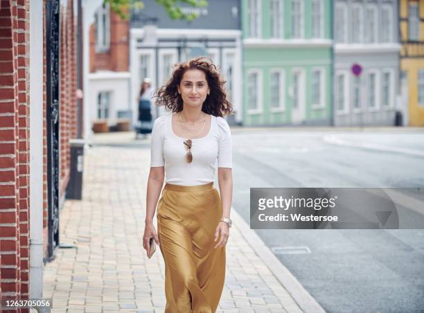 hermosa mujer caminando sobre el pavimento - metallic skirt fotografías e imágenes de stock