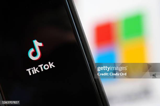 In this photo illustration, a mobile phone featuring the TikTok app is displayed next to the Microsoft logo on August 03, 2020 in New York City....