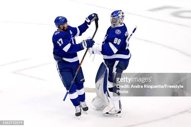 Andrei Vasilevskiy of the Tampa Bay Lightning is congratulated by his teammate Alex Killorn after stopping a shot in the overtime shoot-out to win...