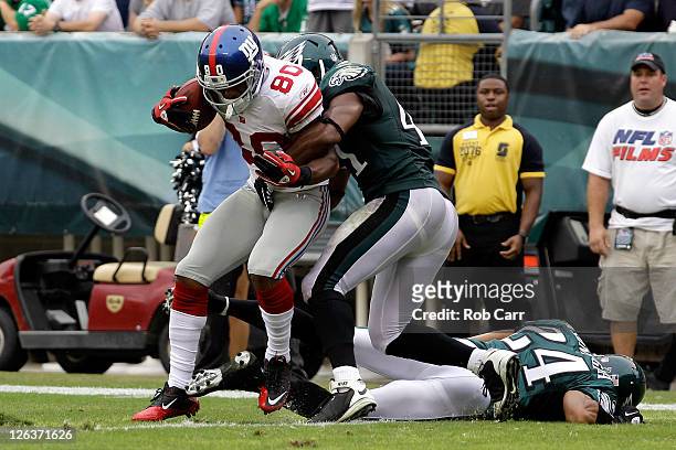 Victor Cruz of the New York Giants scores a touchdown against Jarrad Page of the Philadelphia Eagles and Nnamdi Asomugha during the game at Lincoln...