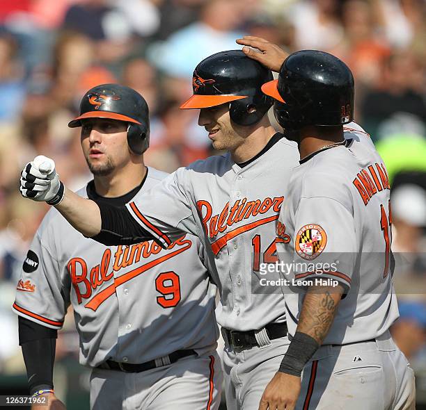 Nolan Reimold of the Baltimore Oriolesis congradualted by Robert Andino and Jake Fox after hitting a three run home run in the eighth inning during...