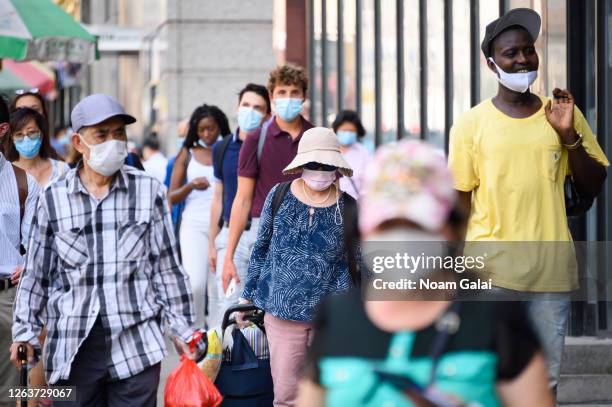 People wear protective face masks in China Town as the city continues Phase 4 of re-opening following restrictions imposed to slow the spread of...