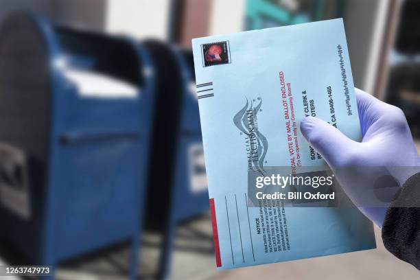 stem per post met handschoen: persoon mailing afwezige stemming het dragen van een beschermende chirurgische handschoen voor het stemmen - amerikaanse presidentsverkiezingen stockfoto's en -beelden